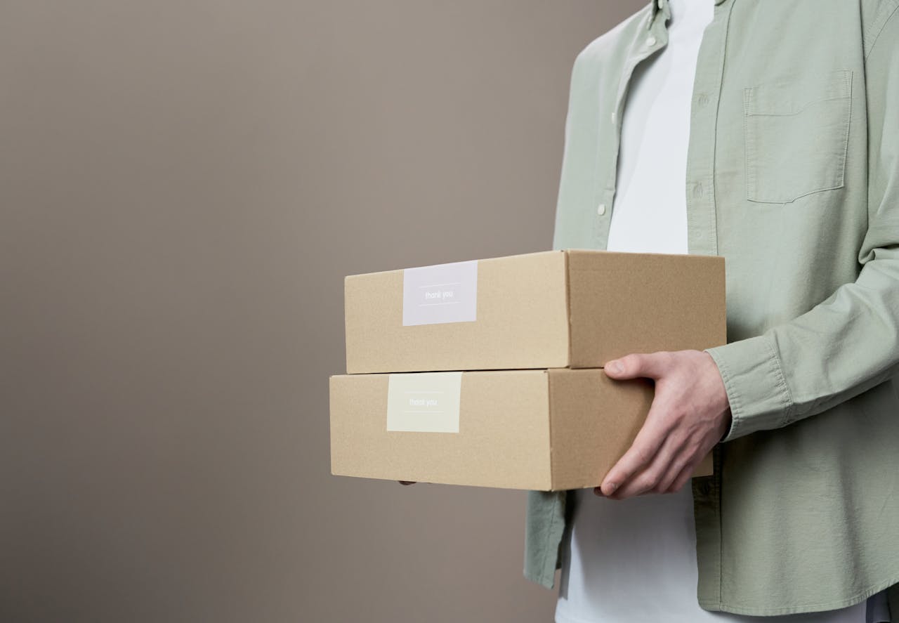 Woman in White Blazer Holding Brown Cardboard Box